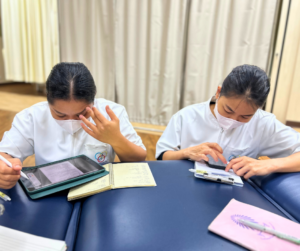 座ってタブレットをみたり、紙にペンで書いているセラピスト２人