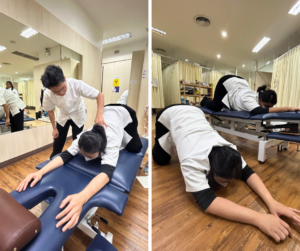 膝を曲げてうつ伏せになり、前方に両手を前に出しているセラピスト2人