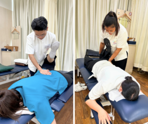 うつ伏せの人の膝から下を持ち上げて、片方の手で腰部を触っている