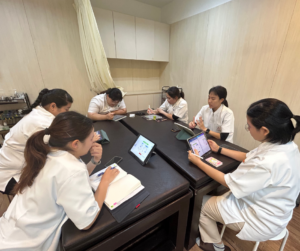 セラピストが6人座ってタブレットをみたり、メモをとったりしている
