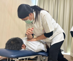 うつ伏せの人を右ひじを使ってマッサージしているセラピスト
