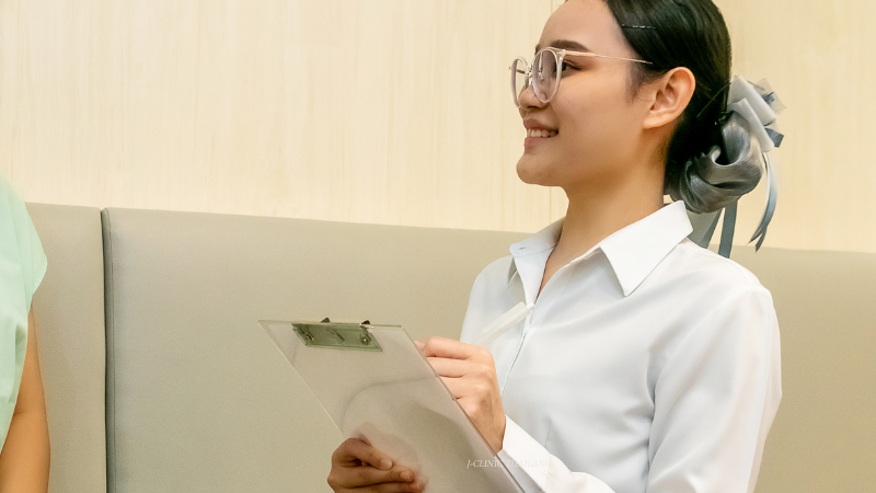 書類とペンをもった女性が笑顔