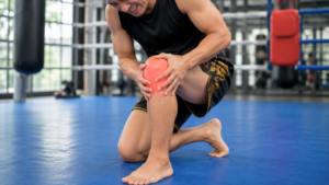 ムエタイトレーニング中にの左痛みを感じる男性。