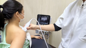 エコー検査のプローブが肩関節にあてられている