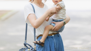 片手で子供を抱きかかえている女性の写真