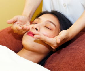 顔の骨格矯正の手技を受ける女性