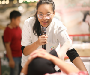 女性がマイクをもってい話している