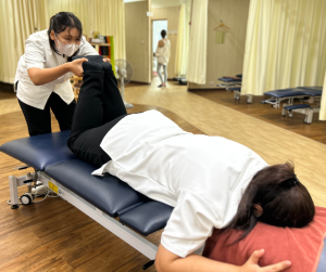腰痛の検査の練習をするスタッフ