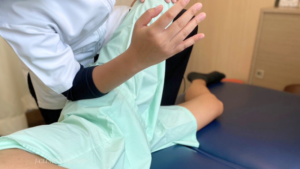 股関節周りの筋肉を緩める手技治療をしているセラピスト