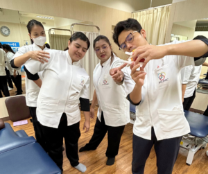 4人のセラピストが話をしている。背骨のもけいをみながら