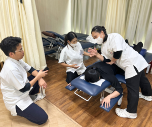 マッサージをするセラピスト、それを見て話をしている男性