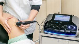 セラピストが患者様の膝に電気治療器のプローブをあてている