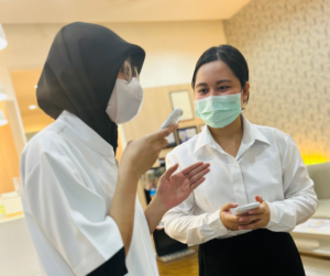女性二人がそれぞれ１台ずつ音声通訳機を手にもっている、一人は通訳機にむかってしゃべっている