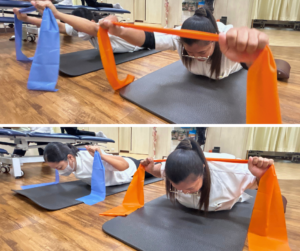 セラピストがうつ伏せになって、頭をあげて、セラバンドを両手でもってトレーニングをしている