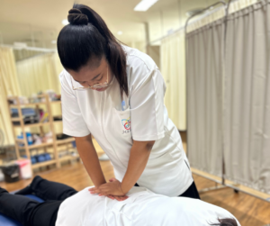 セラピストがうつ伏せになった人の腰の部分をお両手で押している